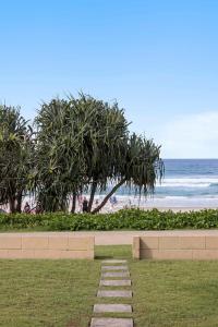 a path leading to a beach with palm trees at Little Waves Tugun in Gold Coast