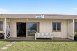 a building with a bench sitting outside of it at Little Waves Tugun in Gold Coast