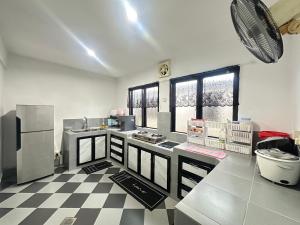 a kitchen with a black and white checkered floor at Ellhavfiz Homestay in Tapah