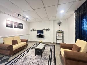 a living room with two couches and a tv at Ellhavfiz Homestay in Tapah