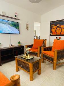 a living room with two couches and a tv at Estancia Dulce Hogar, en pedernales in Pedernales