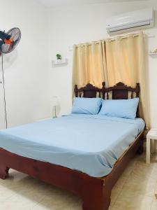 a bedroom with a bed with blue sheets and a window at Estancia Dulce Hogar, en pedernales in Pedernales