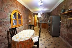 a kitchen with a table and a refrigerator at laurier Rose Hostel in Ourika
