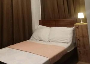 a bedroom with a bed with a lamp on a dresser at Bayanihan flats Condo in Pajak +6 photos
