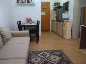 a living room with a couch and a table and a kitchen at Bayanihan flats Condo in Pajak