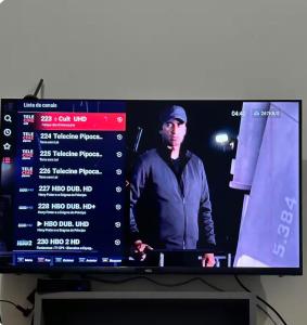 a television screen with a man on the screen at Apartamento Aconchegante 3 in Doutor Lund