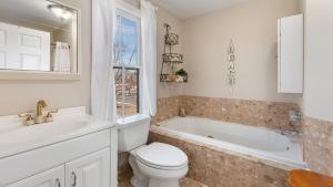 a bathroom with a toilet and a tub and a sink at Summer Winds Sanctuary in Cape May +32 photos