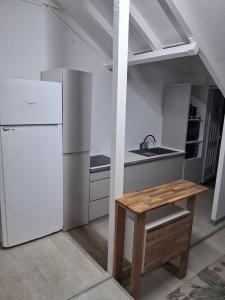 a kitchen with a white refrigerator and a wooden table at La terrasse in Baie-Mahault
