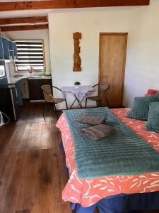 a room with two beds and a table and a kitchen at Hospedaje henua roa 2 in Hanga Roa