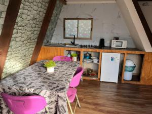 a kitchen with a table and pink chairs at Hospedaje henua roa 2 in Hanga Roa +12 photos
