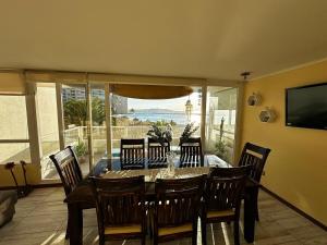 a dining room with a table and chairs and a television at Laguna del Mar, C 208 in La Serena