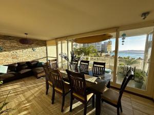 a dining room with a table and chairs and a view of the ocean at Laguna del Mar, C 208 in La Serena