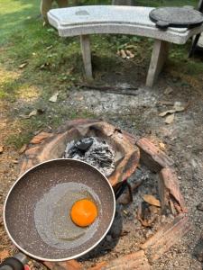 an egg is cooking in a pan over a fire at Boon Homestay & Cafe บุญโฮมสเตย์ in Ban Buak Khang