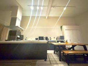 a kitchen with a counter and a table and lights at 民宿 浪漫 in Fujikawaguchiko +12 photos