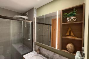 a bathroom with a shower and a sink and a glass shower stall at Studio Beira-Mar na Praia dos Carneiros in Tamandaré
