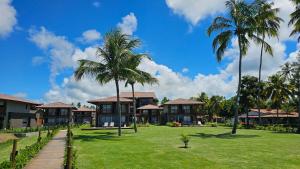 a view of a resort with palm trees and grass at Studio Beira-Mar na Praia dos Carneiros in Tamandaré