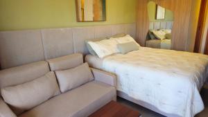 a bedroom with a large bed and a couch at Studio Beira-Mar na Praia dos Carneiros in Tamandaré +22 photos