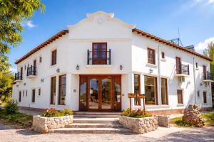 a white house with a sign in front of it at Hotel Maria Cafayate in San Carlos