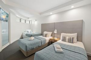a bedroom with two beds and a window at Sirocco 507 by G1 Holidays in Mooloolaba +10 photos