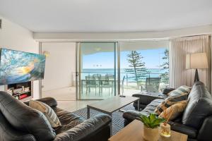 a living room with leather furniture and a view of the ocean at Sirocco 507 by G1 Holidays in Mooloolaba