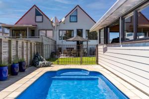 a swimming pool on the side of a house at Tangaroa Beachside Bliss - with Private Pool in Whangamata