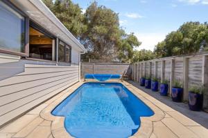 a swimming pool on the deck of a house at Tangaroa Beachside Bliss - with Private Pool in Whangamata