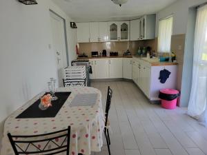a kitchen with a table and chairs and a kitchen with white cabinets at A Serene Studio in Vieux Fort