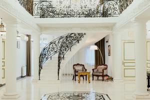 a living room with a staircase with a chandelier at Hotel Jardin in Belgrade