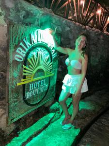 a woman in a bikini standing in front of a sign at Orika del Mar Hotel in Isla Grande