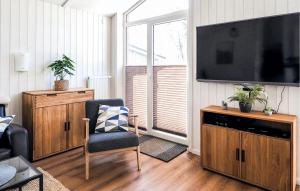a living room with a television and a chair at Schatzkiste 3 - Dorf 4 in Travemünde