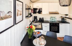 a kitchen with a table with a vase of flowers on it at Schatzkiste 3 - Dorf 4 in Travemünde