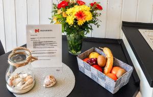 a table with a bowl of fruit and a vase of flowers at Schatzkiste 3 - Dorf 4 in Travemünde +17 photos