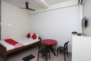 a room with a bed and a table and chairs at Hotel O Nandi Inn in Durgāpur