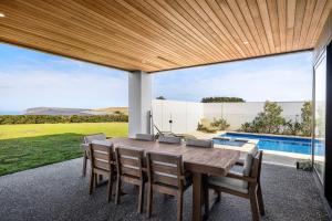 a dining room with a table and chairs and a pool at Island View San Remo in San Remo