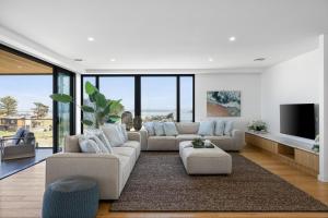 a living room with two couches and a tv at Island View San Remo in San Remo