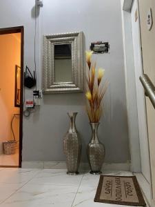 two vases sitting on a floor with a mirror at chick nina in Barra do Garças