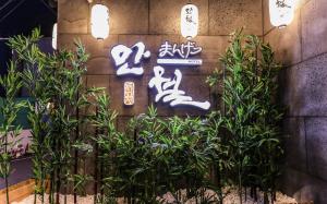 a sign on a wall with plants and lights at Manwol Hotel in Ŭmnae
