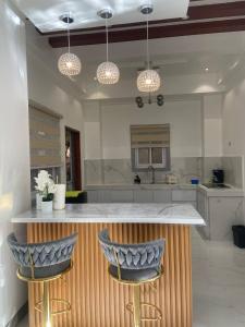 a kitchen with a counter with two blue bar stools at Mira Transient in Bantay