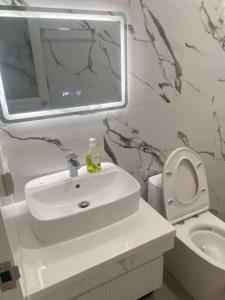 a bathroom with a sink and a toilet and a mirror at Mira Transient in Bantay