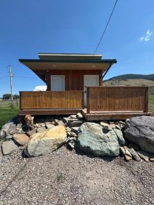 a dog laying in front of a house with rocks at LakeView Landing - Stunning Views Overlooking Bay in Big Arm
