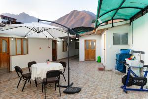 a table with chairs and an umbrella on a patio at Comfortable apartment in Urubamba in Urubamba