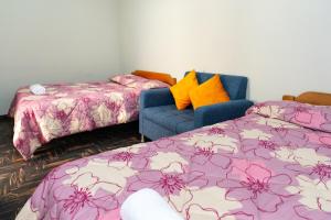 a room with two beds and a blue couch at Comfortable apartment in Urubamba in Urubamba