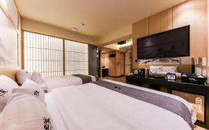 a hotel room with a bed and a flat screen tv at Manwol Hotel in Ŭmnae