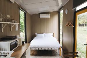 a small bedroom with a bed and a microwave at Lanyin Hut in Shui-t'ien