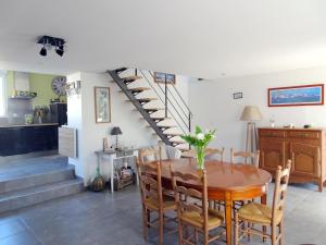 a dining room with a table and a staircase at Stone House in Bricqueville near Sandy Beach in Bricqueville-sur-Mer