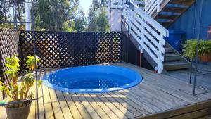 a blue swimming pool on a wooden deck at Lily Home in Algarrobo