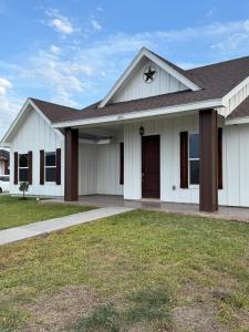 a white house with a brown roof at Dream Casa Blanca in Harlingen