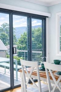 a dining room with a table and chairs and a large window at The Gables Berry in Berry