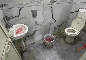 a dirty bathroom with a toilet and a sink at Sagar hotel and guest house in Sāgar