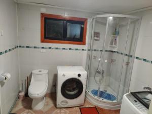 a bathroom with a shower and a washing machine at Casa amoblada en Punta arenas in Punta Arenas +9 photos